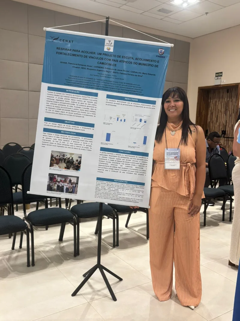 Estudante ao lado de banner no congresso